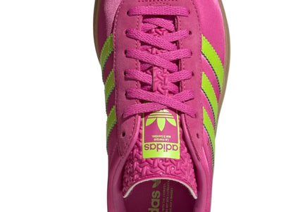 Pink Adidas sneaker with green accents on a light gray background